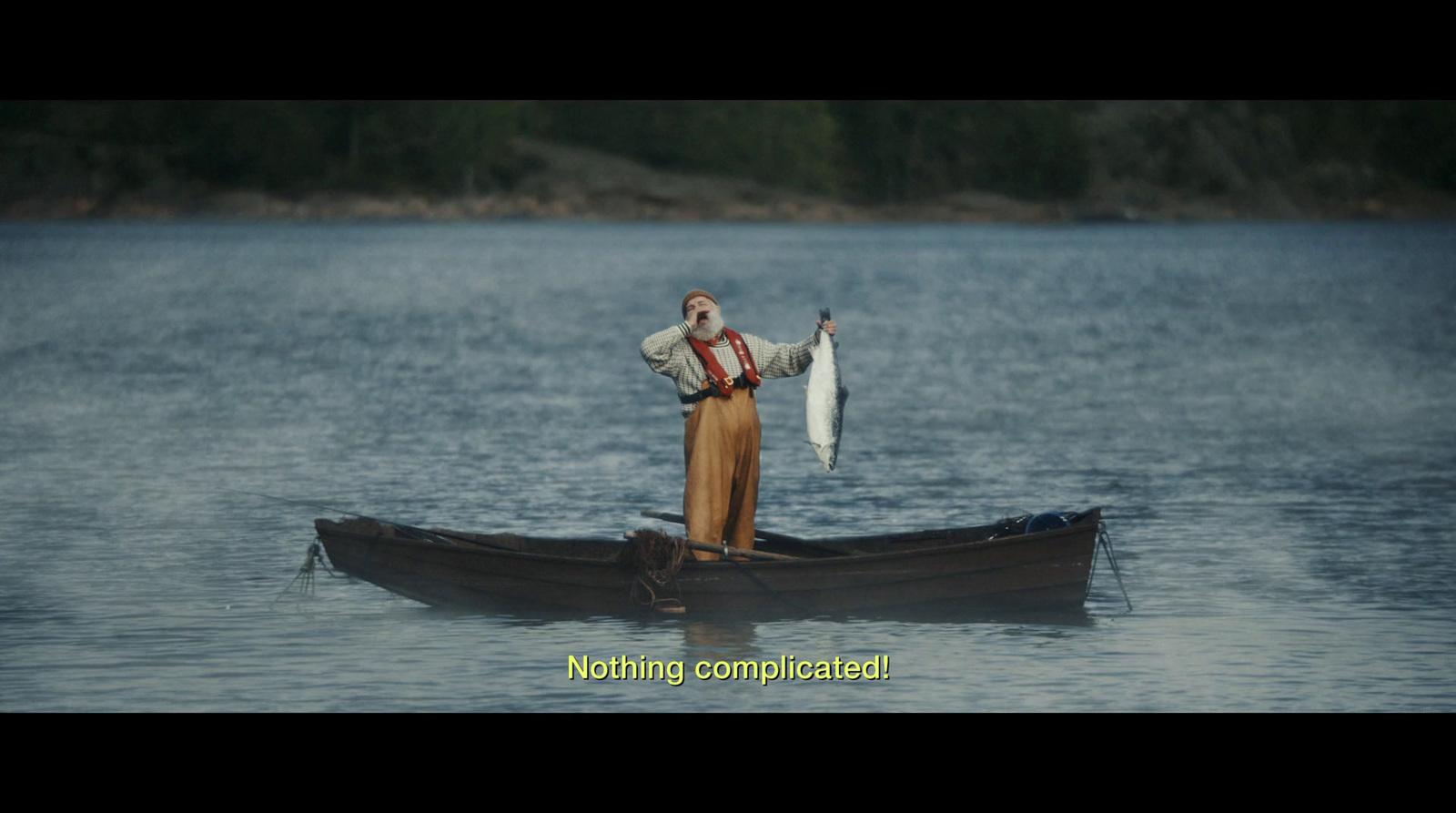 a man standing in a boat holding a fish