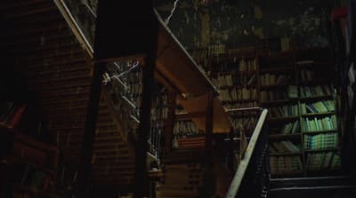 a staircase leading up to a bookshelf filled with books