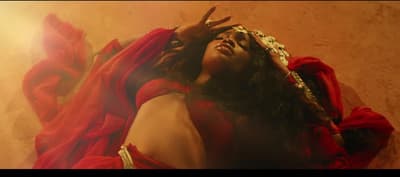 a woman in a red dress with her hands on her head