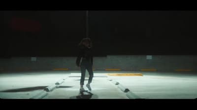 a person standing on a skateboard in a parking lot