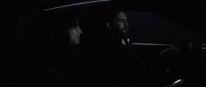 a man and a woman sitting in a car at night