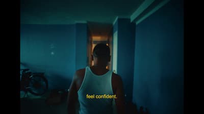 a woman in a tank top is walking down a hallway