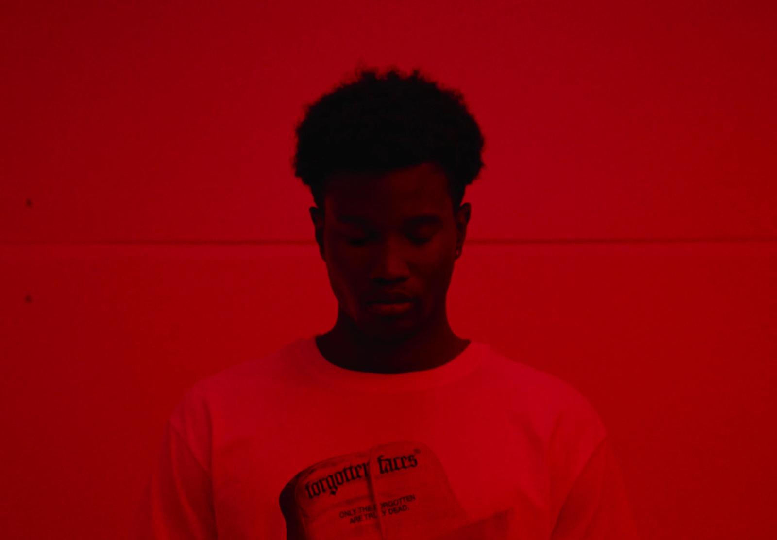 a man standing in front of a red wall