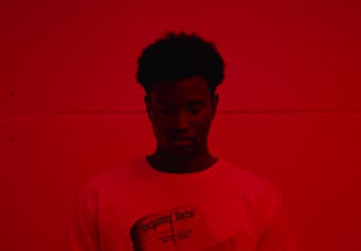 a man standing in front of a red wall