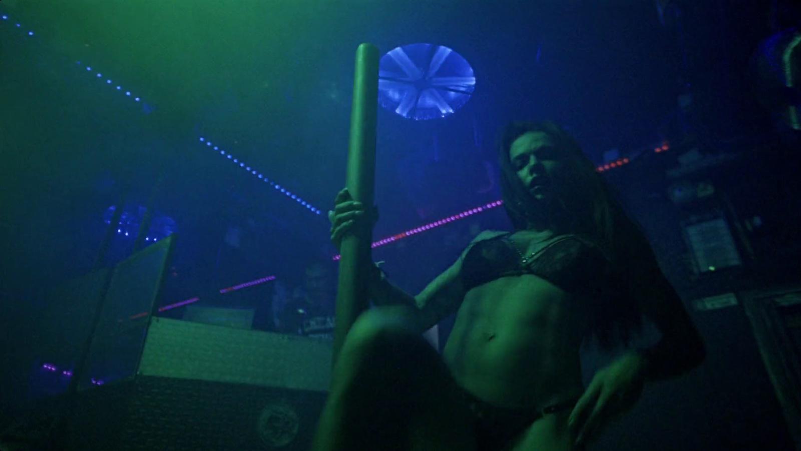 a woman holding a pole in a dark room