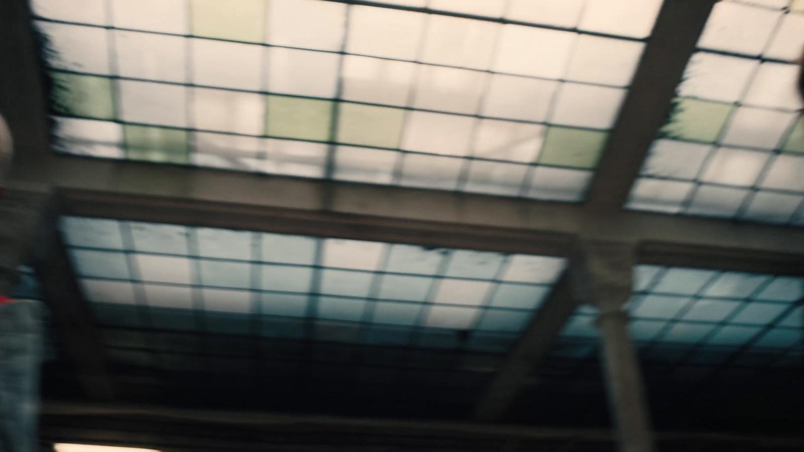 a man holding a red stop sign under a glass roof