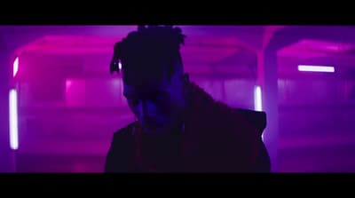a man with dreadlocks standing in a dark tunnel