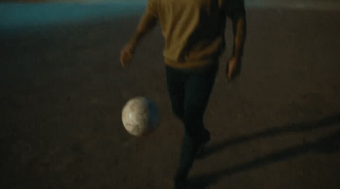 a man is kicking a soccer ball on the ground