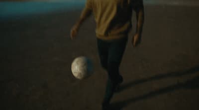 a man is kicking a soccer ball on the ground