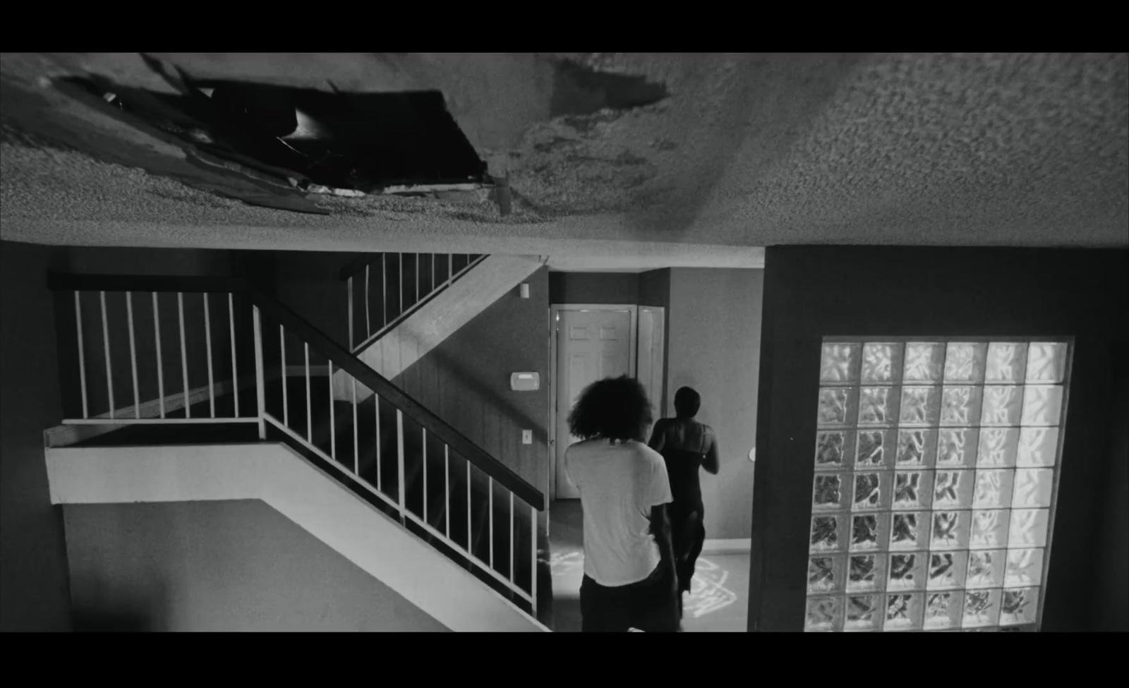 a woman standing in a room next to a stair case