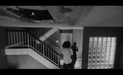 a woman standing in a room next to a stair case