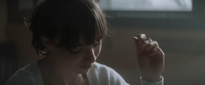 a woman holding a cigarette in her right hand