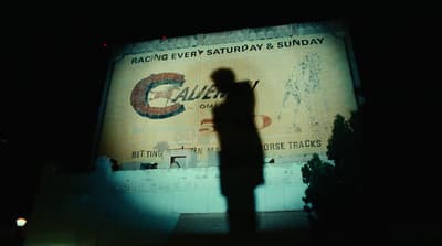 a silhouette of a person standing in front of a building