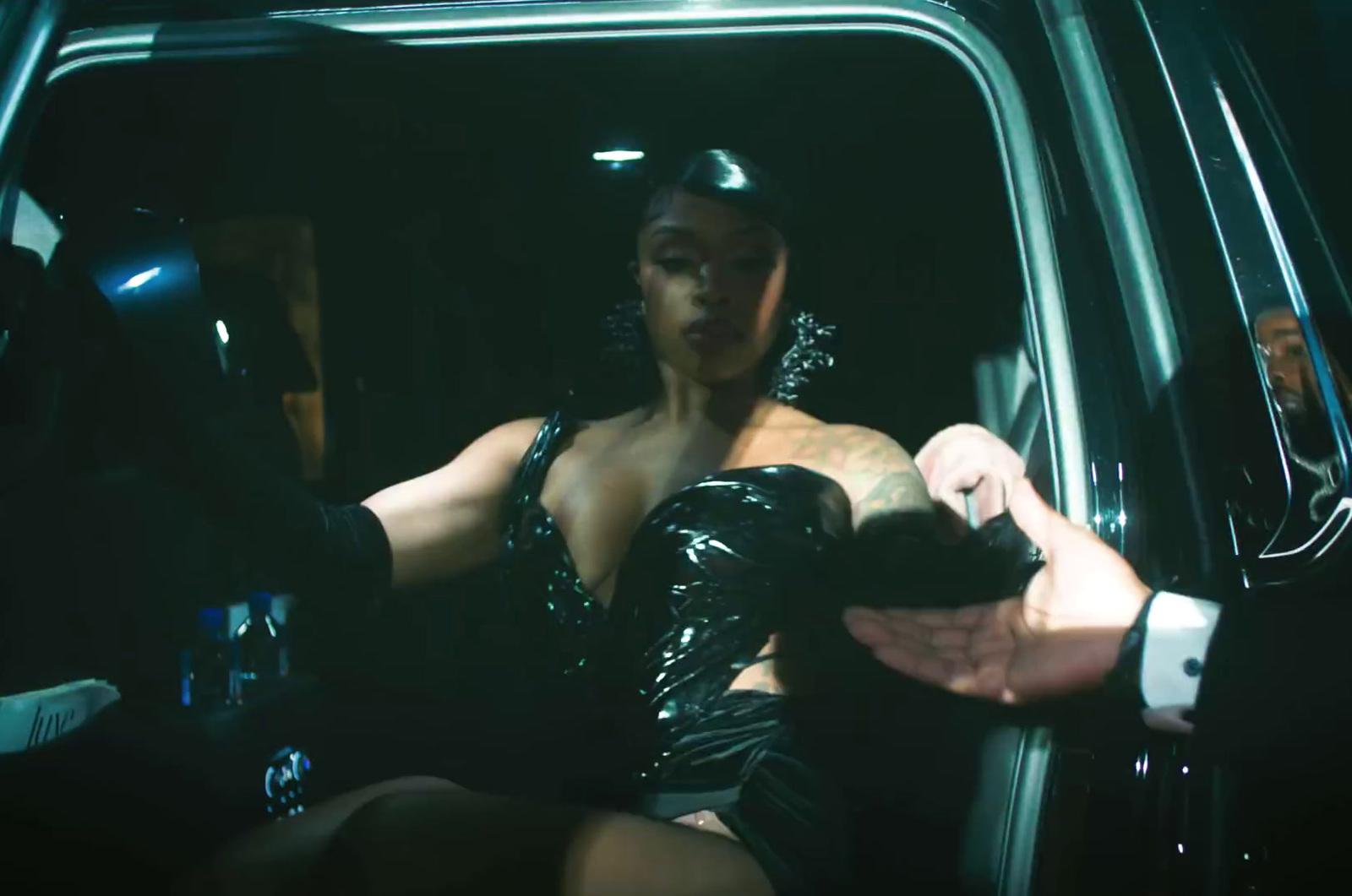 a woman in a black dress sitting in a car