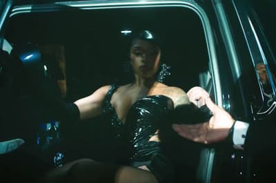 a woman in a black dress sitting in a car