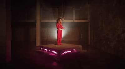 a woman in a red outfit standing on a platform