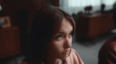 a woman sitting next to a man in a room
