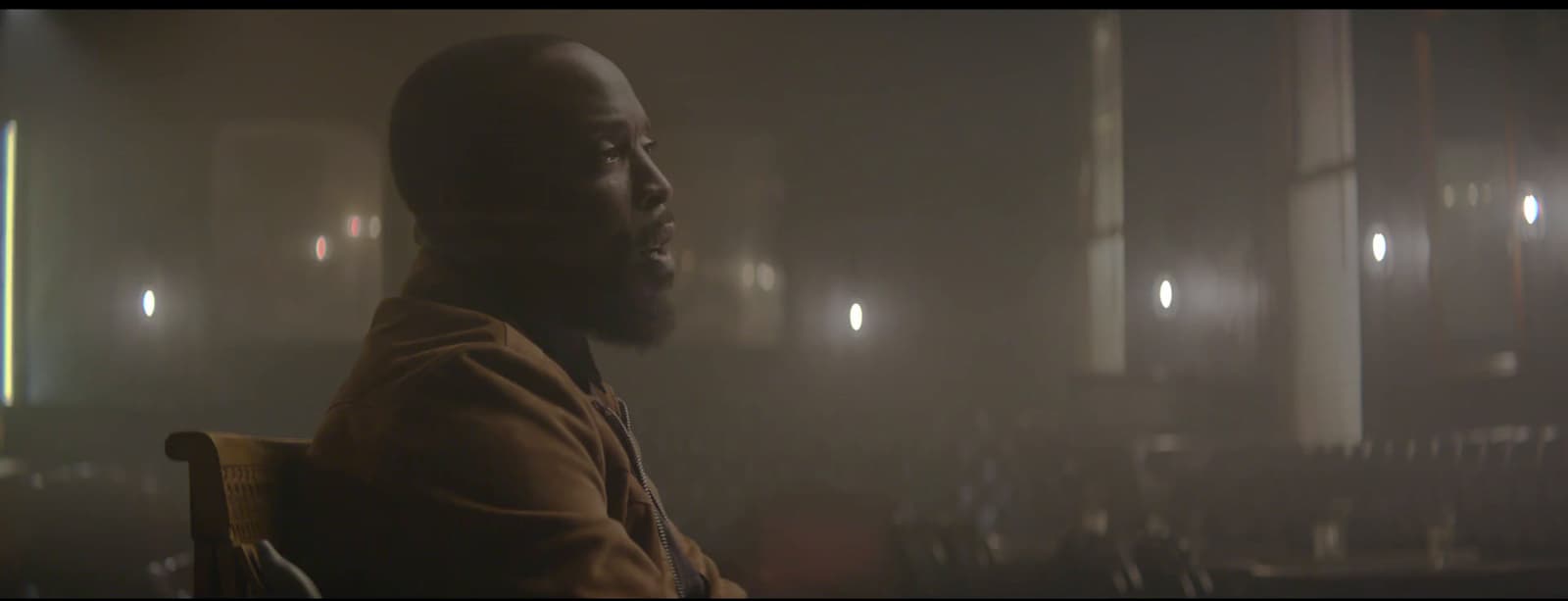 a man sitting in a chair in a dark room