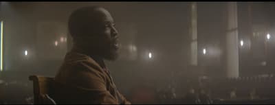 a man sitting in a chair in a dark room