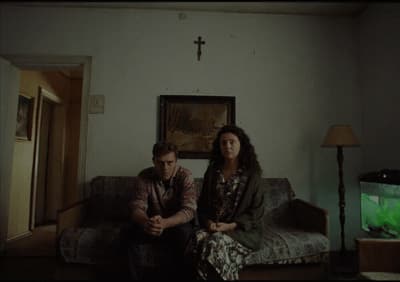 a man and woman sitting on a couch in a living room
