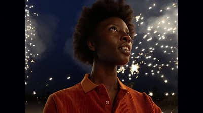 a woman looking up at fireworks in the sky
