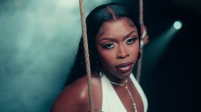 a woman in a white dress holding a rope