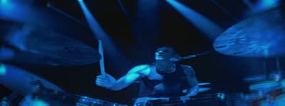 a man playing drums on stage at a concert