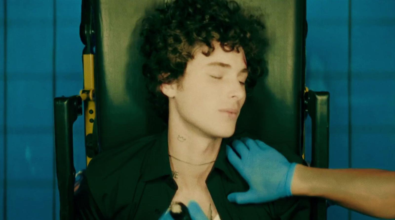 a man in a black shirt and blue gloves
