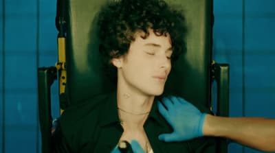 a man in a black shirt and blue gloves