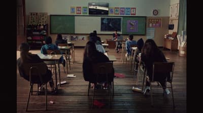 a group of students sitting at desks in a classroom