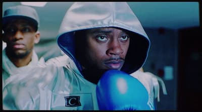 a man wearing a hoodie and boxing gloves