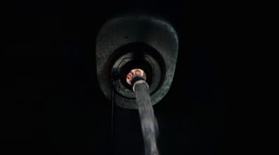 a person's hand coming out of a pipe in the dark