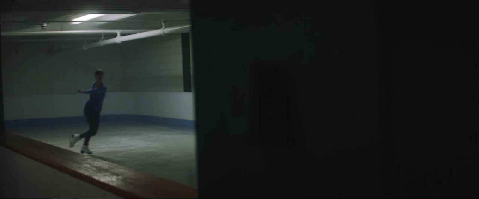 a woman skating on an ice rink at night