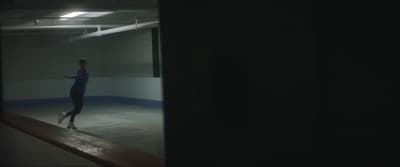 a woman skating on an ice rink at night