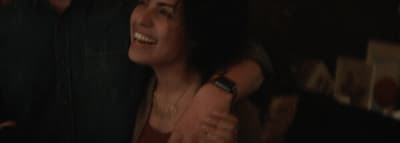 a woman smiling and holding a cell phone