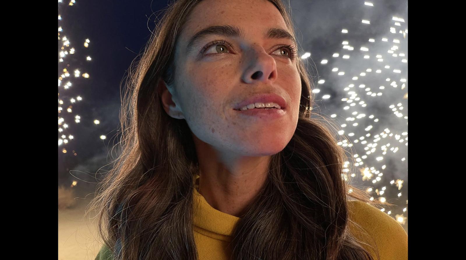 a woman looking up at fireworks in the sky