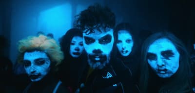 a group of people with their faces painted white