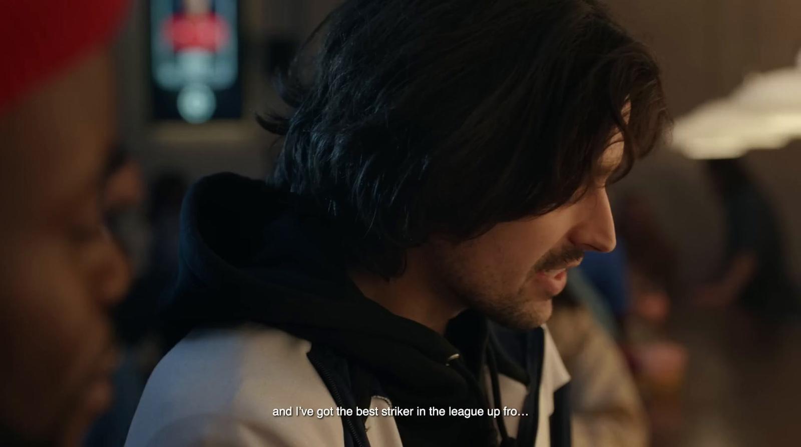 a man with long hair wearing a hoodie
