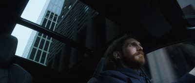 a man sitting in a car looking out the window