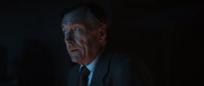 a man in a suit and tie in a dark room