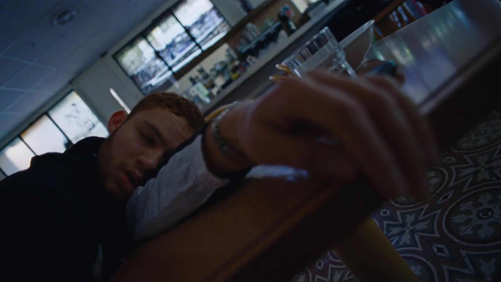 a man sitting at a table with a cigarette in his mouth