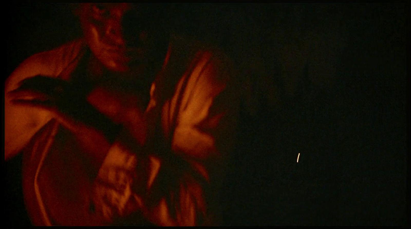 a man standing in the dark with his arms crossed