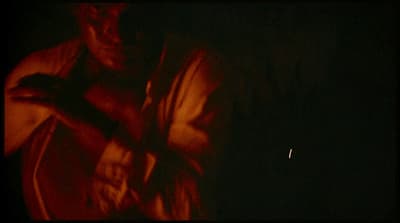 a man standing in the dark with his arms crossed
