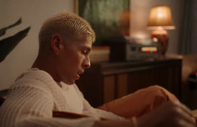 a man sitting on a couch looking at his cell phone