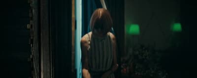 a woman standing in a doorway with a knife in her hand