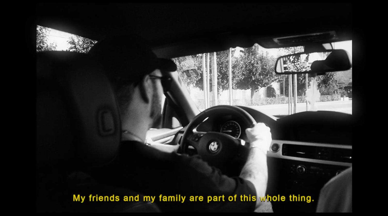 a man driving a car while holding a steering wheel