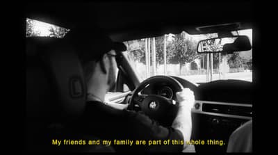 a man driving a car while holding a steering wheel