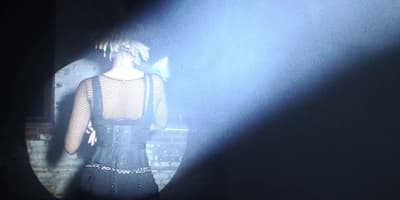 a woman in a black dress standing in a dark room