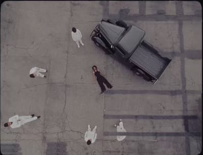 a group of people standing around a parked car
