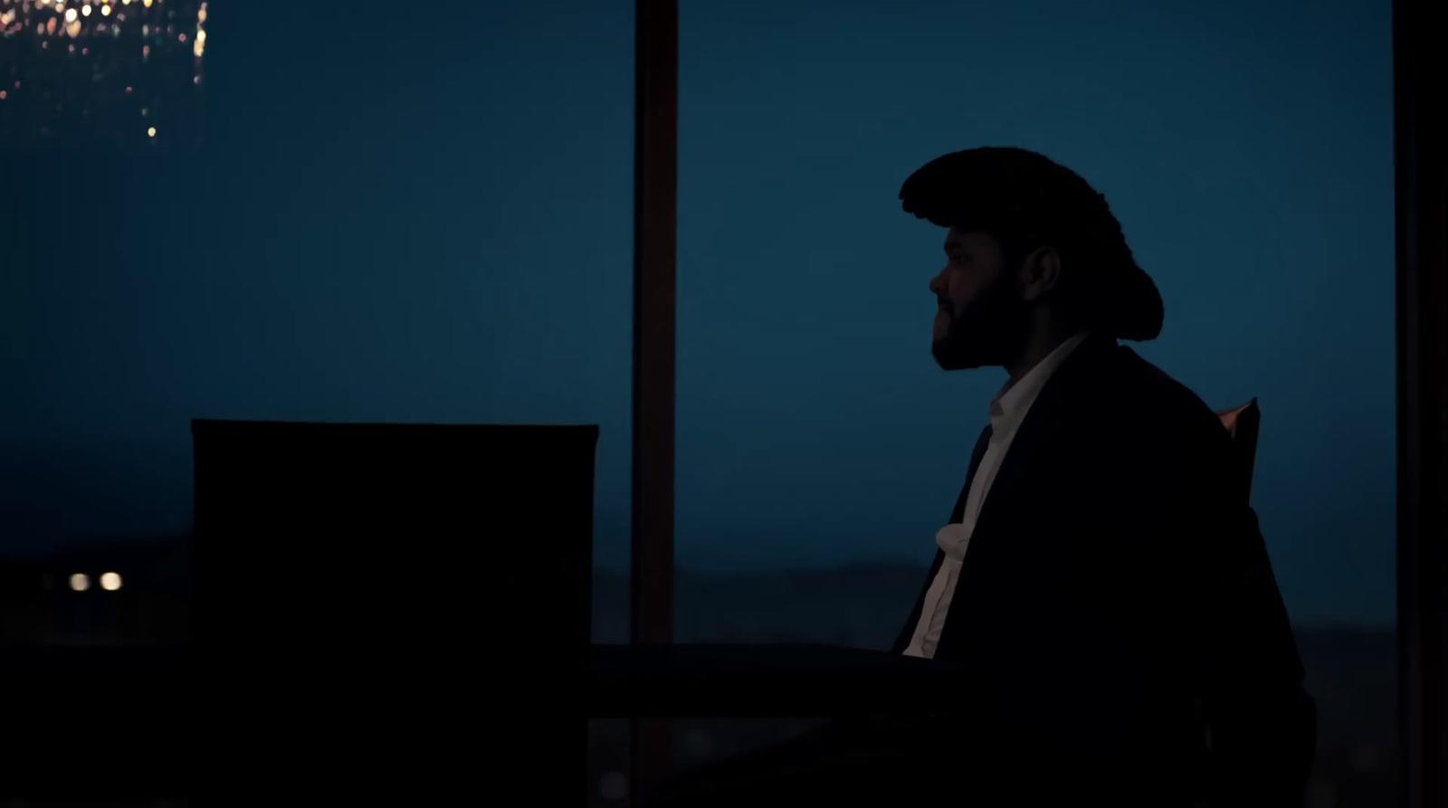 a man standing in front of a window at night